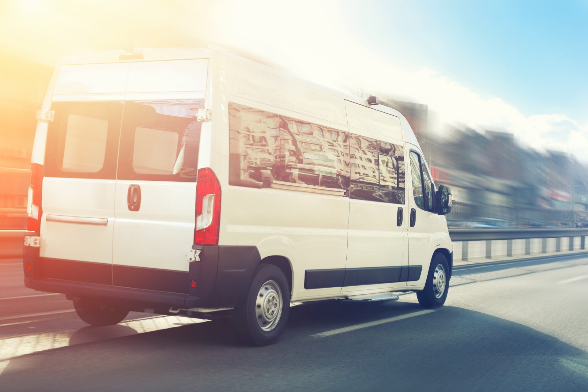 Baker's Transit white high-top transportation van traveling on an East Bay roadway