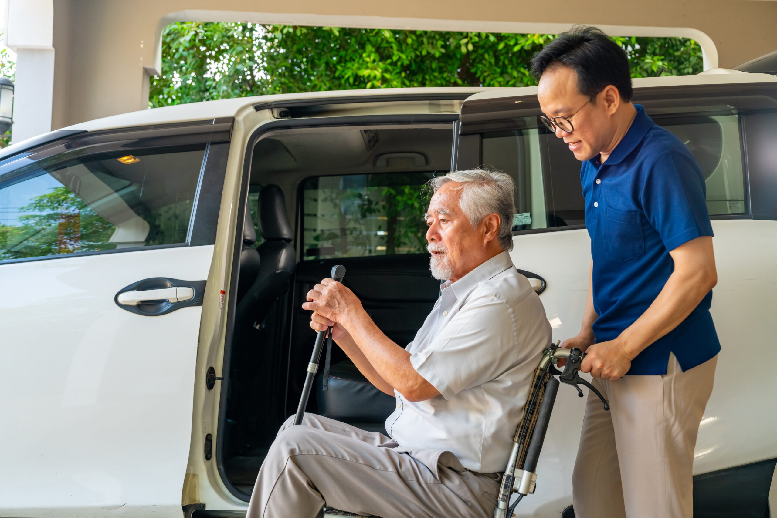 Caregiver pushing elderly man in wheelchair