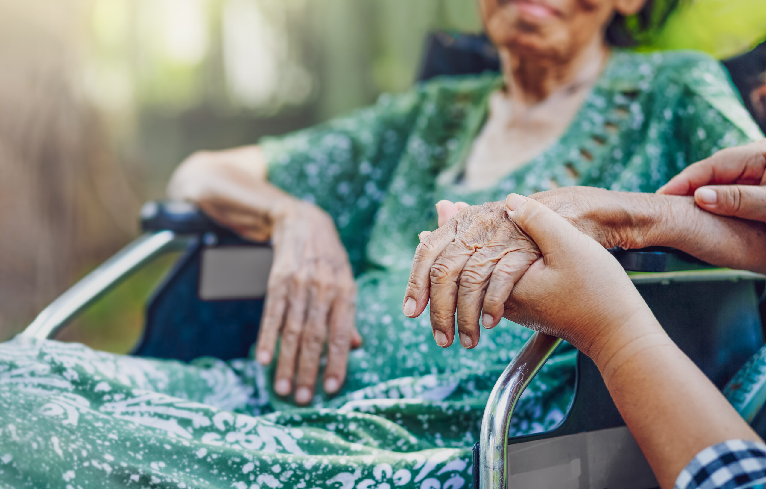 Assisted transportation service caretaker holding hand of anxious elderly patient